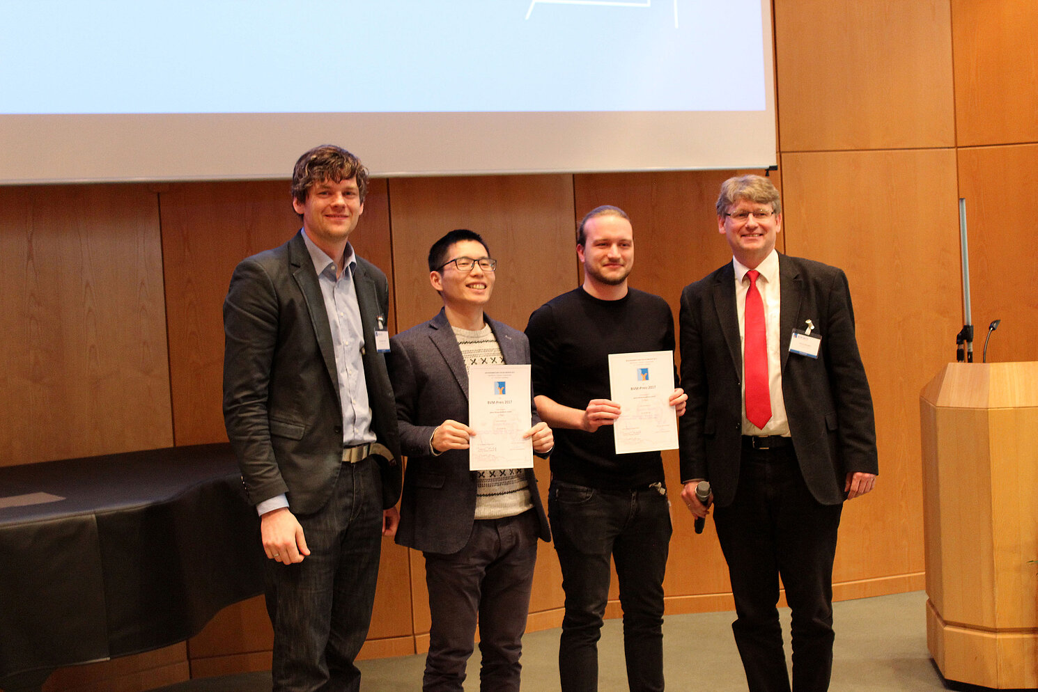 Preisverleihung: Robert Mendel (3. v.l.) vom ReMIC der OTH Regensburg, Tagungsleiter PD. Dr. Klaus Maier-Hein vom Deutschen Krebsforschungszentrum (DKFZ) (1. v.l.) und Prof. Dr. Heinz Handel von der Universität zu Lübeck (1. v.r.). Foto: DFKZ Heidelberg