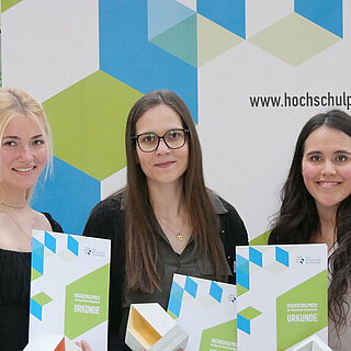 Christine Braun (Mitte) von der OTH Regensburg hat den mit 3000 Euro dotierten Hochschulpreis 2023 gewonnen. Auf dem zweiten bzw. dritten Platz landeten Juliana Grosser (r., TU München) und Maike Bihlmeier (HS München). Foto: Julia Gleiss/LBB Bayern