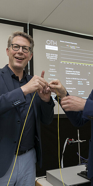 Zwei Männer verbinden ein Kabel über eine Steckverbindung.