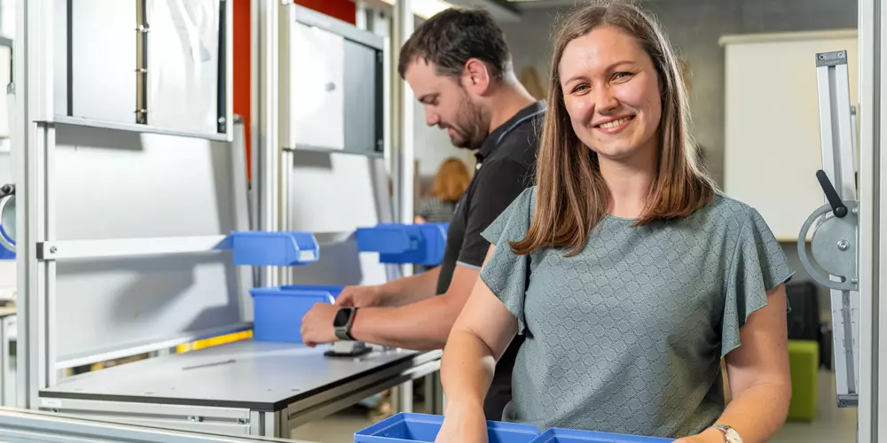 Studierende arbeiten im LeanLab an einer Fertigungsstrecke. 