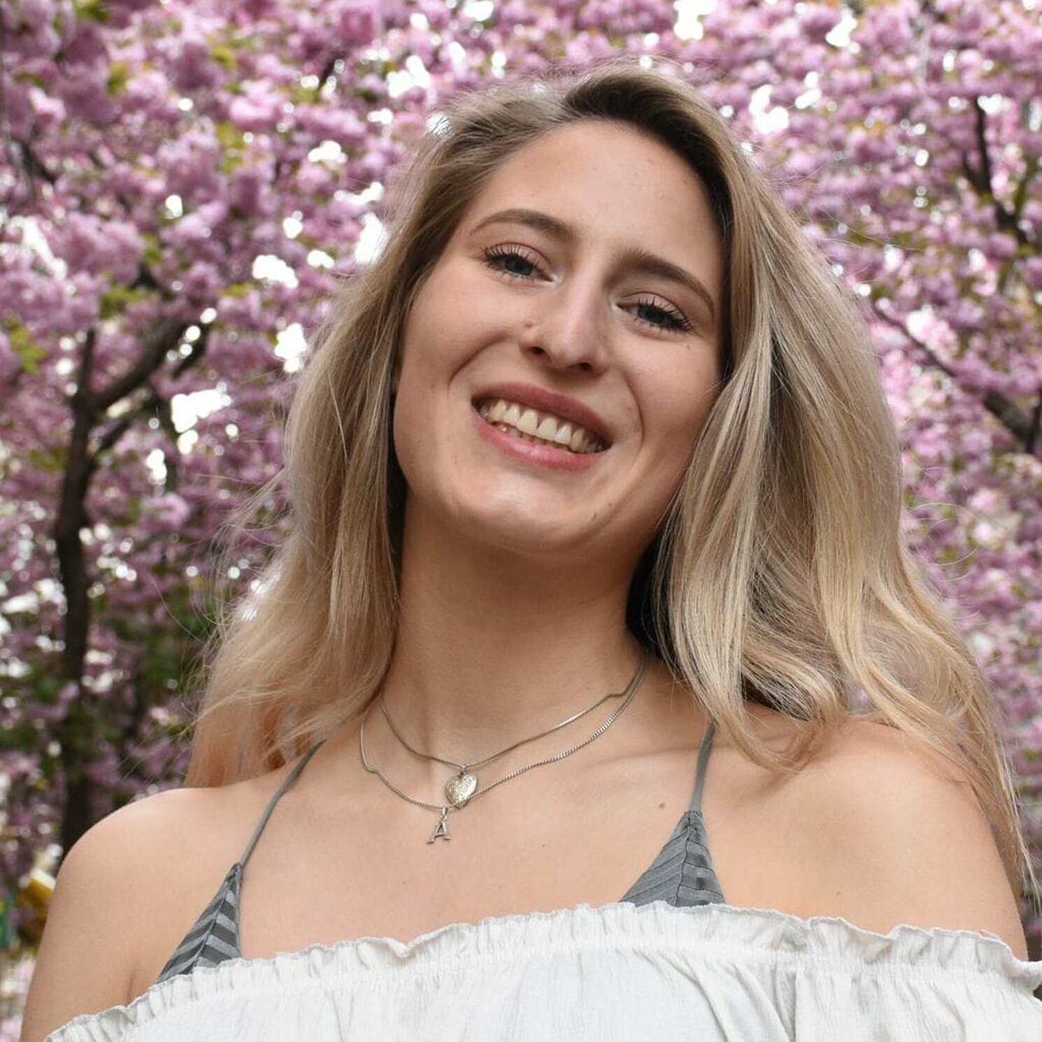 Auf dem Foto ist eine Person von schräg unten zu sehen, die lächelt.