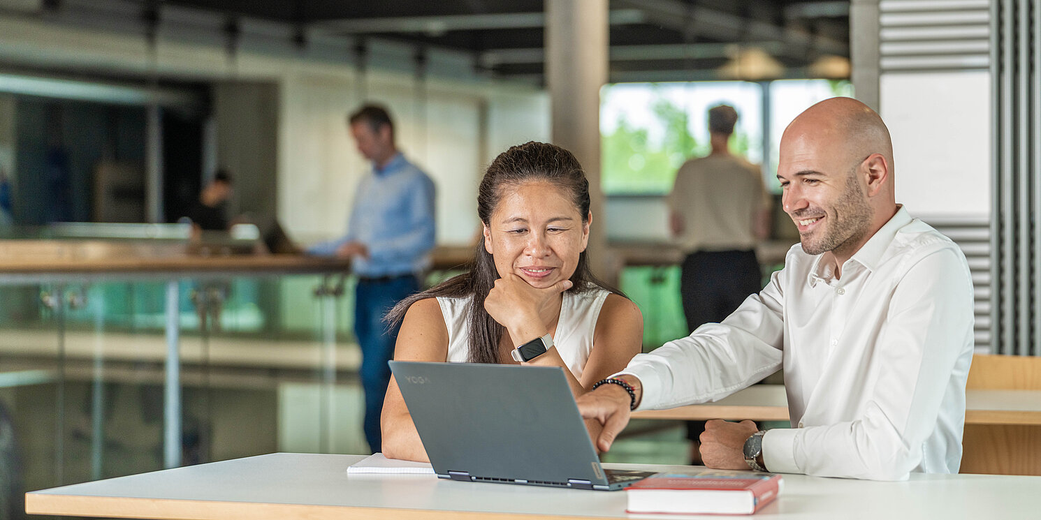 Business Administration – General Management berufsbegleitend studieren Zwei Studierende lernen gemeinsam an einem Tisch sitzend.