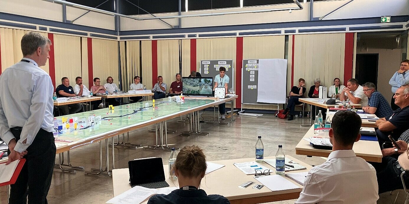 Man sieht die Teilnehmer des Workshops in einem Raum sitzen