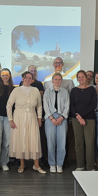 Ein Gruppenfoto mit allen Teilnehmenden des Seminar, vor einer Leinwand, welche die Folie zeigt "Chronische Wunden...verbinden..."