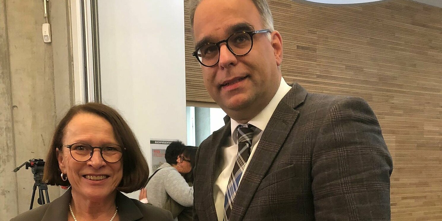 Oberbürgermeisterin Gertrud Malz-Schwarzfischer überreicht Wolfgang Voigt den druckfrischen Almanach. Foto: Roman Danzer Eine Frau und ein Mann stehen nebeneinander und lächeln in die Kamera. Der Mann hält ein aufgeschlagenes Buch in die Kamera.