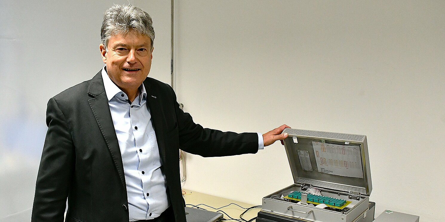 Prof. Dr. Rainer Holmer steht vor einem Prototypen. 