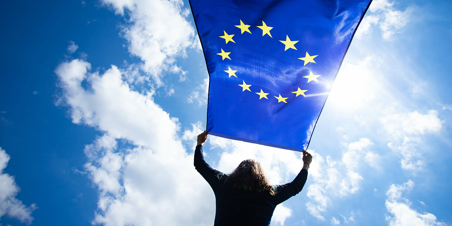 Eine Frau hält die EU-Fahne.