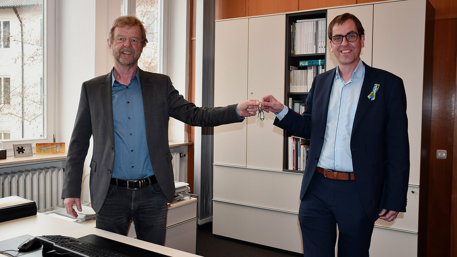 Symbolische Schlüsselübergabe am 15. März 2022 im Präsidentenbüro: Prof. Dr. Wolfgang Baier (li.) und Prof. Dr. Ralph Schneider. Foto: OTH Regensburg/Michael Hitzek