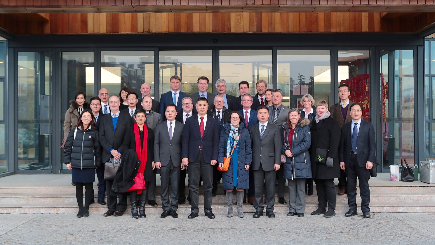 Die Regensburger Delegation, darunter der Präsident der OTH Regensburg Prof. Dr. Wolfgang Baier (hinterste Reihe, 2. von rechts), mit chinesischen Partnern vor dem „Grünen Haus“ im Sino-German Ecopark in Qingdao.