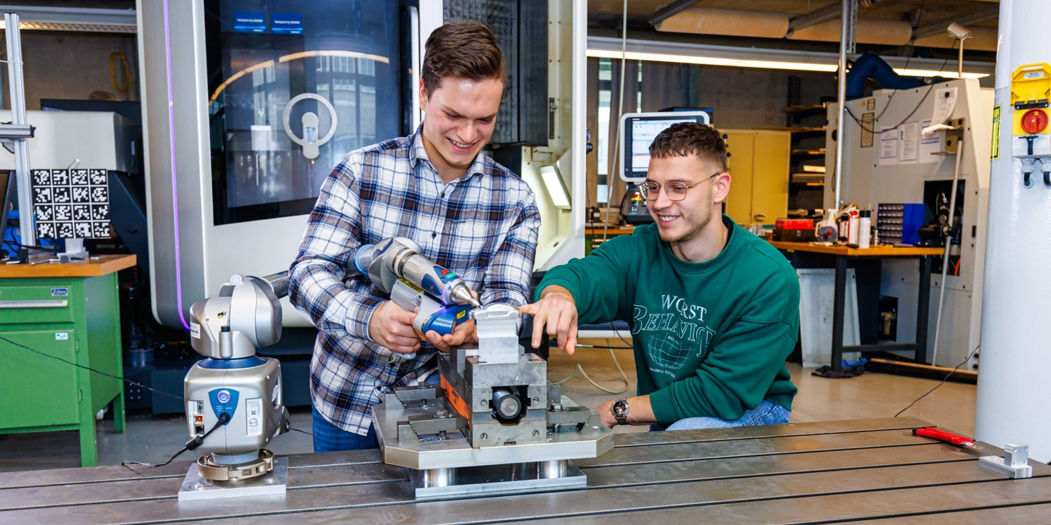 Zwei Studenten im LFW bei der Arbeit an einem Gerät