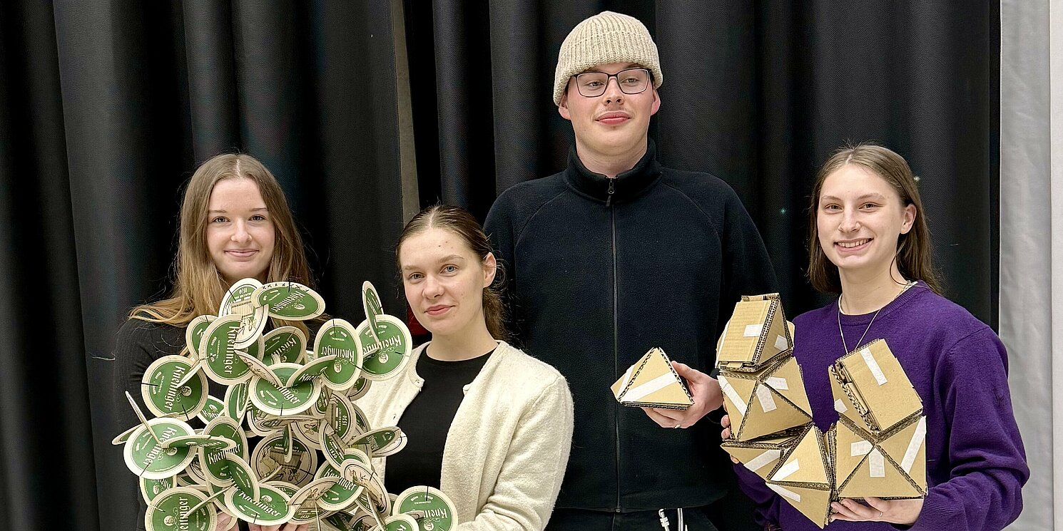 Vier Studierende halten selbstgebauten Modelle 