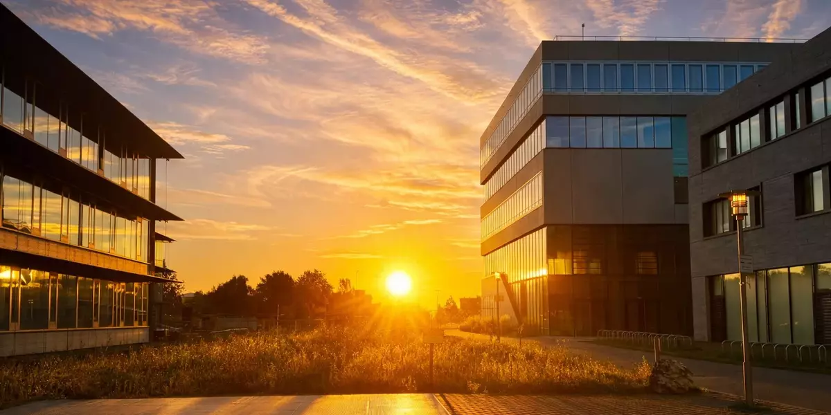 Campus zwischen Gebäude Maschinenbau, Gebäude IM und Gebäude Architektur im Sonnenaufgang.