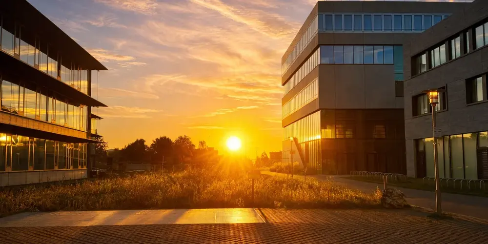 Campus zwischen Gebäude Maschinenbau, Gebäude IM und Gebäude Architektur im Sonnenaufgang.