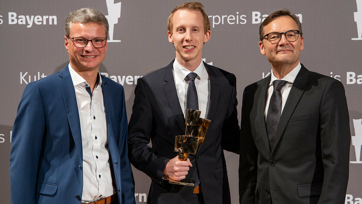 Preisträger Martin Schöll (mitte) mit Bayernwerk-Vorstandsvorsitzendem Reimund Gotzel (rechts) und dem Bayerischen Staatsminister für Wissenschaft und Kunst, Bernd Sibler. (Foto: Bayernwerk AG)
