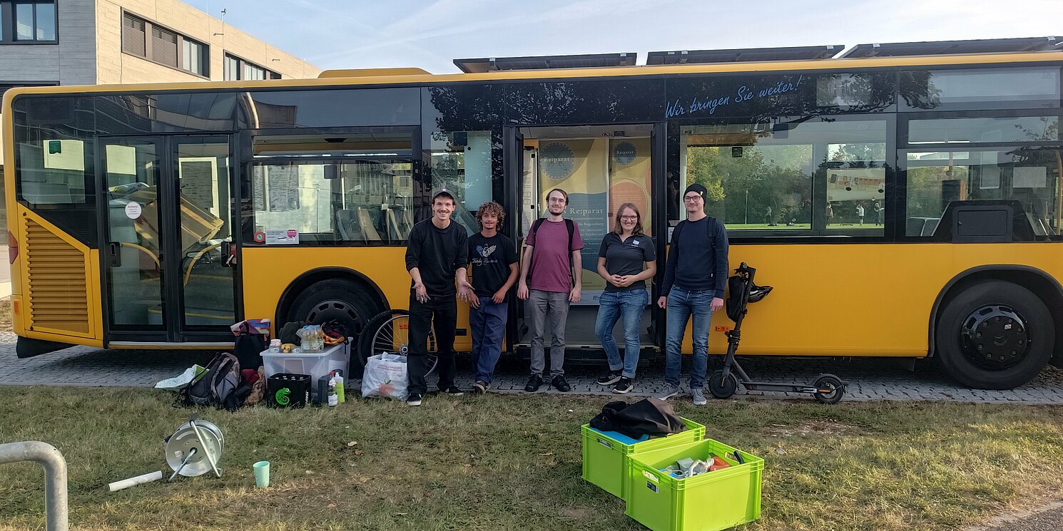 Gruppenbild des Reparaturteams vor dem Bus des Green Offices.