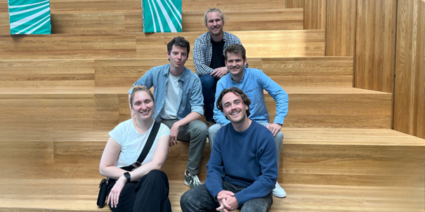 Vier Personen der OTH Regensburg sitzen auf der Treppe beim Das Team der OTH Regensburg (oben: Alexander Meisinger, mittig v.l.n.r.: Leon Schumm, Anton Achhammer, unten v.l.n.r.: Elisabeth Hockemeyer, Marco Schamel) beim diesjährigen Projektreffen im Fraunhofer IEE, Kassel. 