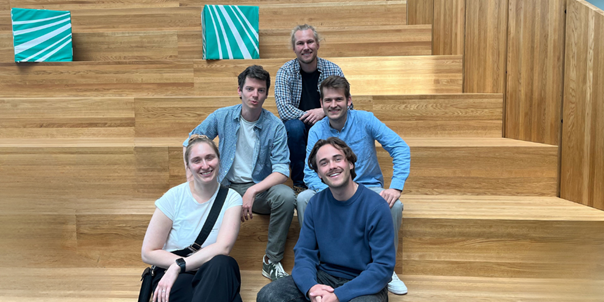 Vier Personen der OTH Regensburg sitzen auf der Treppe beim Das Team der OTH Regensburg (oben: Alexander Meisinger, mittig v.l.n.r.: Leon Schumm, Anton Achhammer, unten v.l.n.r.: Elisabeth Hockemeyer, Marco Schamel) beim diesjährigen Projektreffen im Fraunhofer IEE, Kassel. 