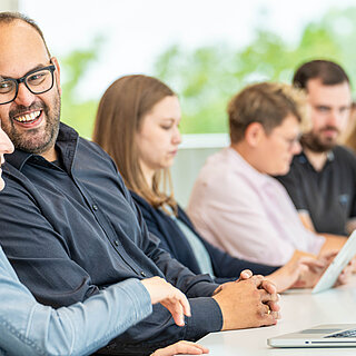 Studierende lernen und unterhalten sich in einem Seminarraum. 