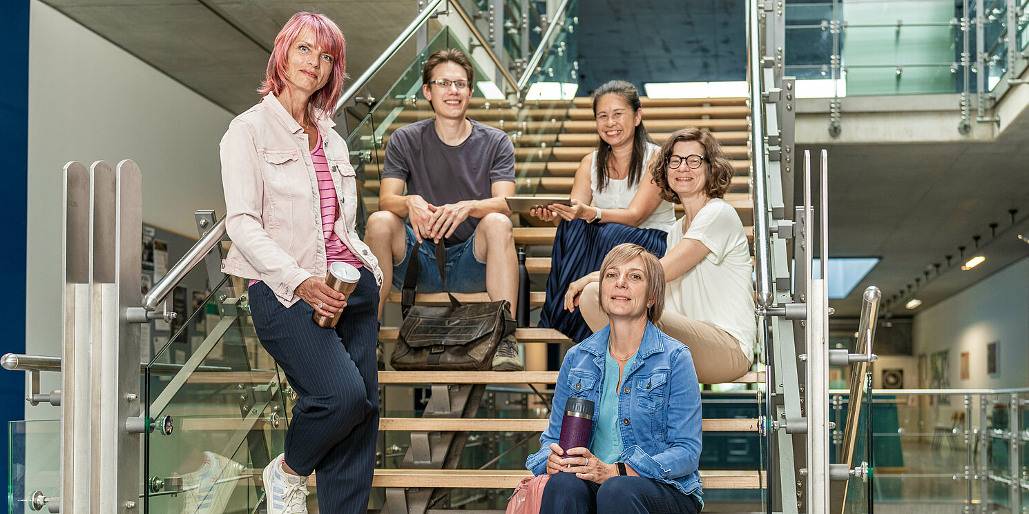 Studierende sitzen auf einer Treppe.