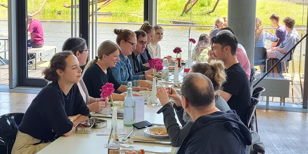 Mitarbeitende der OTH Regensburg sitzen an einem dekorierten Mensatisch