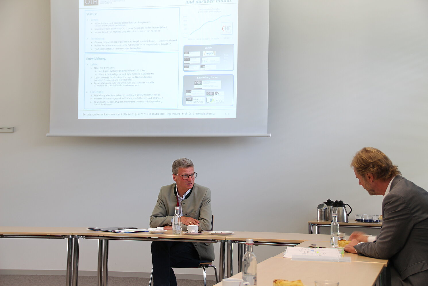 Wissenschaftsminister Bernd Sibler (li.)  und der Präsident der OTH Regensburg  Prof. Dr. Wolfgang Baier (re.) nehmen an einer Videokonferenz über die KI-Projekte der OTH Regensburg teil.