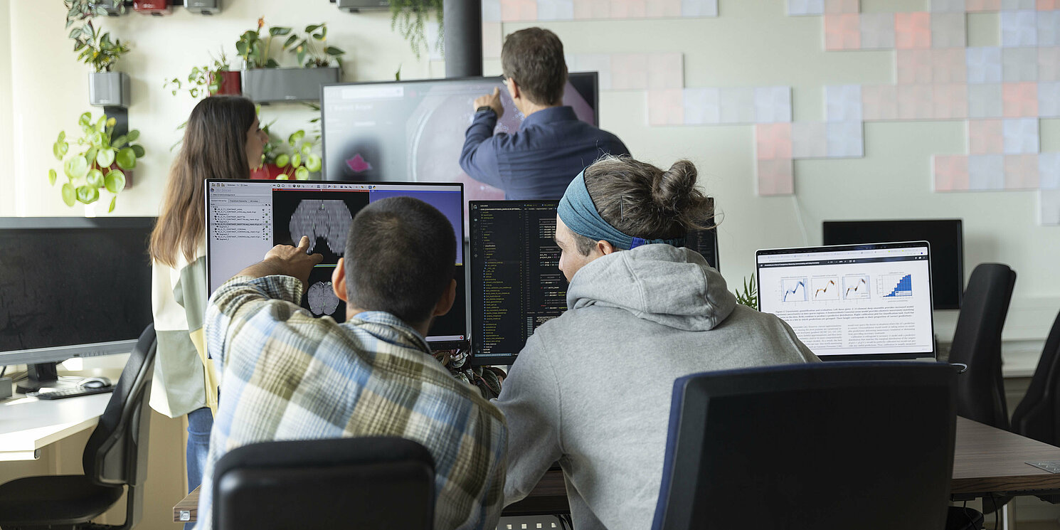 Mehrere Personen arbeiten in einem Labor mit PCs