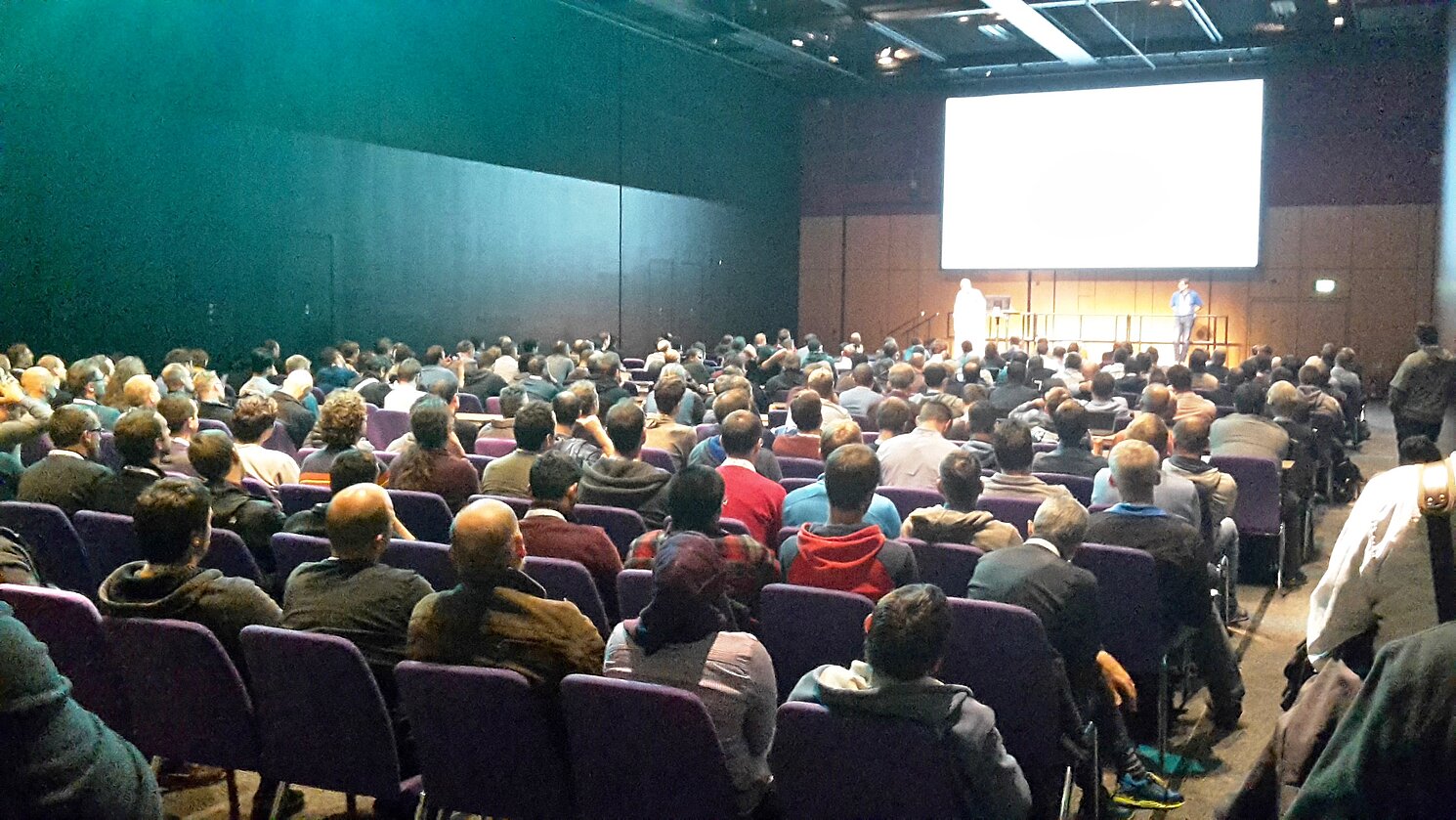 Ralf Ramsauer vom Labor für Digitalisierung der OTH Regensburg spricht vor mehr als 300 Zuhörerinnen und Zuhörern auf der Embedded Linux Conference Europe in Edinburgh in einem bis auf den letzten Platz gefüllten Saal.