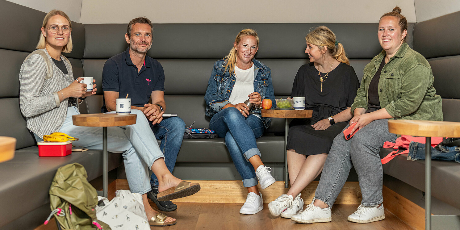 Module aus dem Bachelor Systemtechnik berufsbegleitend absolvieren Studierende sitzen in der Cafeteria zusammen und unterhalten sich.