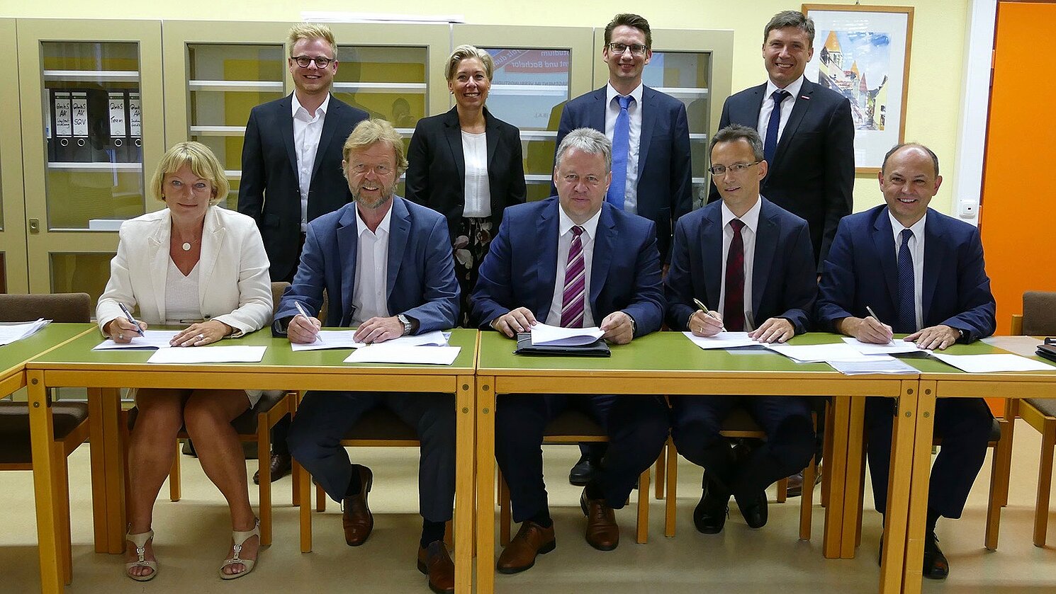 Bei der Vertragsunterzeichnung. Vorne, von links: Prof. Dr. Andrea Klug, Prof. Dr. Wolfgang Baier, Richard Reisinger, Bernhard Kleierl, Walter Schütz. Hinten, von links: Thomas Feyrer, Sabine Märtin, Ralf Kohl und Wolfgang Reif.