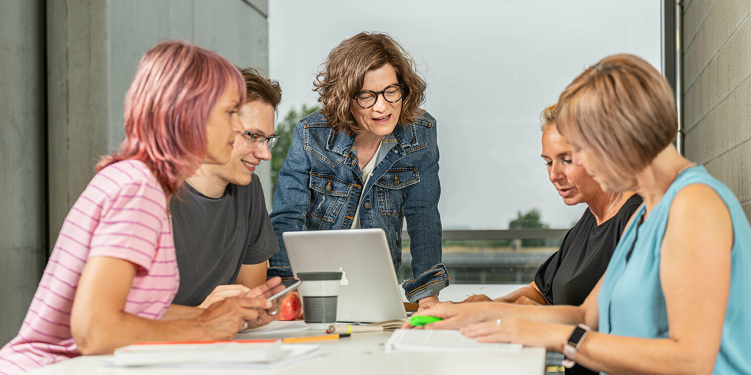 Eine Lerngruppe arbeitet gemeinsam an einem Tisch.