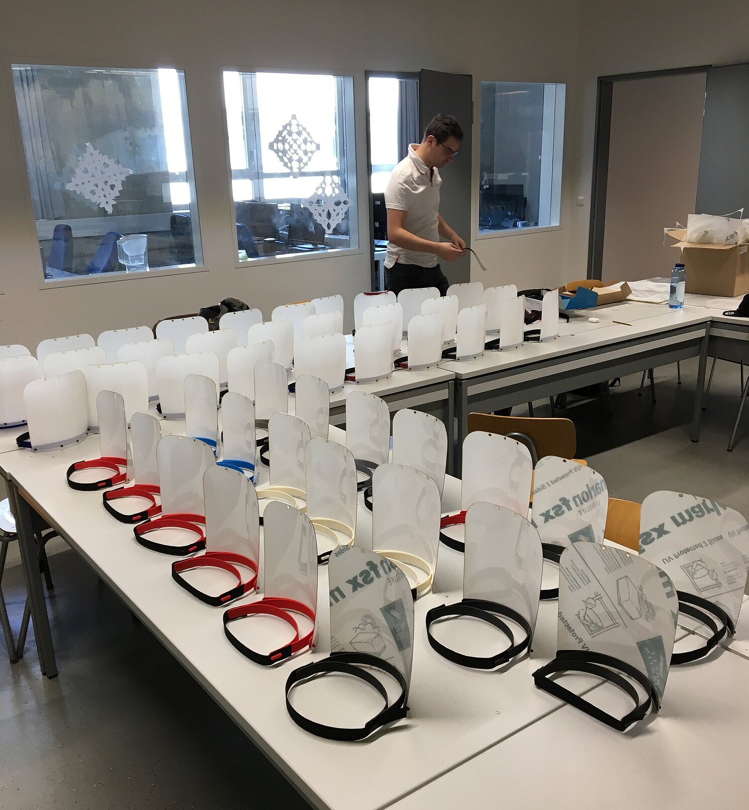 Labor-Mitarbeiter David Kandler beim Zusammenbau der fertigen Face Shields.