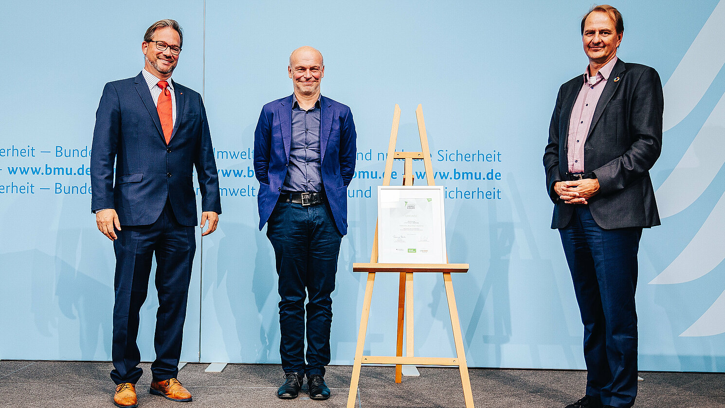 Architekt Christian Kirchberger (Mitte) erhielt den Preis vom Parlamentarischen Staatssekretär Florian Pronold (li.) und dem Leiter des Bundesumweltamts, Prof. Dr. Dirk Messner. Foto: Christoph Wehrer/BMU