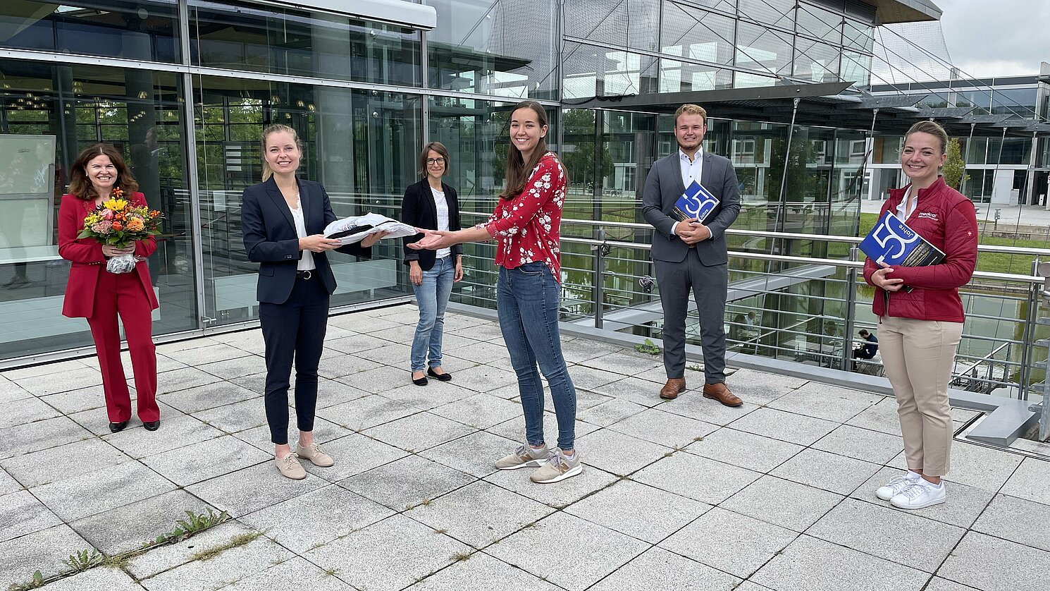 Lena Grewe (2.v.li.) überreichte symbolisch eine Garnitur der Arbeitskleidung an die Studierende Anna Kinn. Mit dabei (v.li.) Prof. Dr. Christa Mohr, Studiengangkoordinatorin Verena Hämmerle, Patrick-Benedikt Mensing und Nadja Hofmann. Foto: OTH Regensburg/Michael Hitzek
