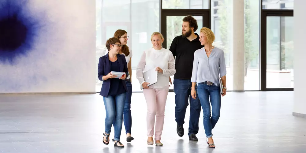 Fünf Personen gehen in einer Gruppe durch das Informatik-Foyer