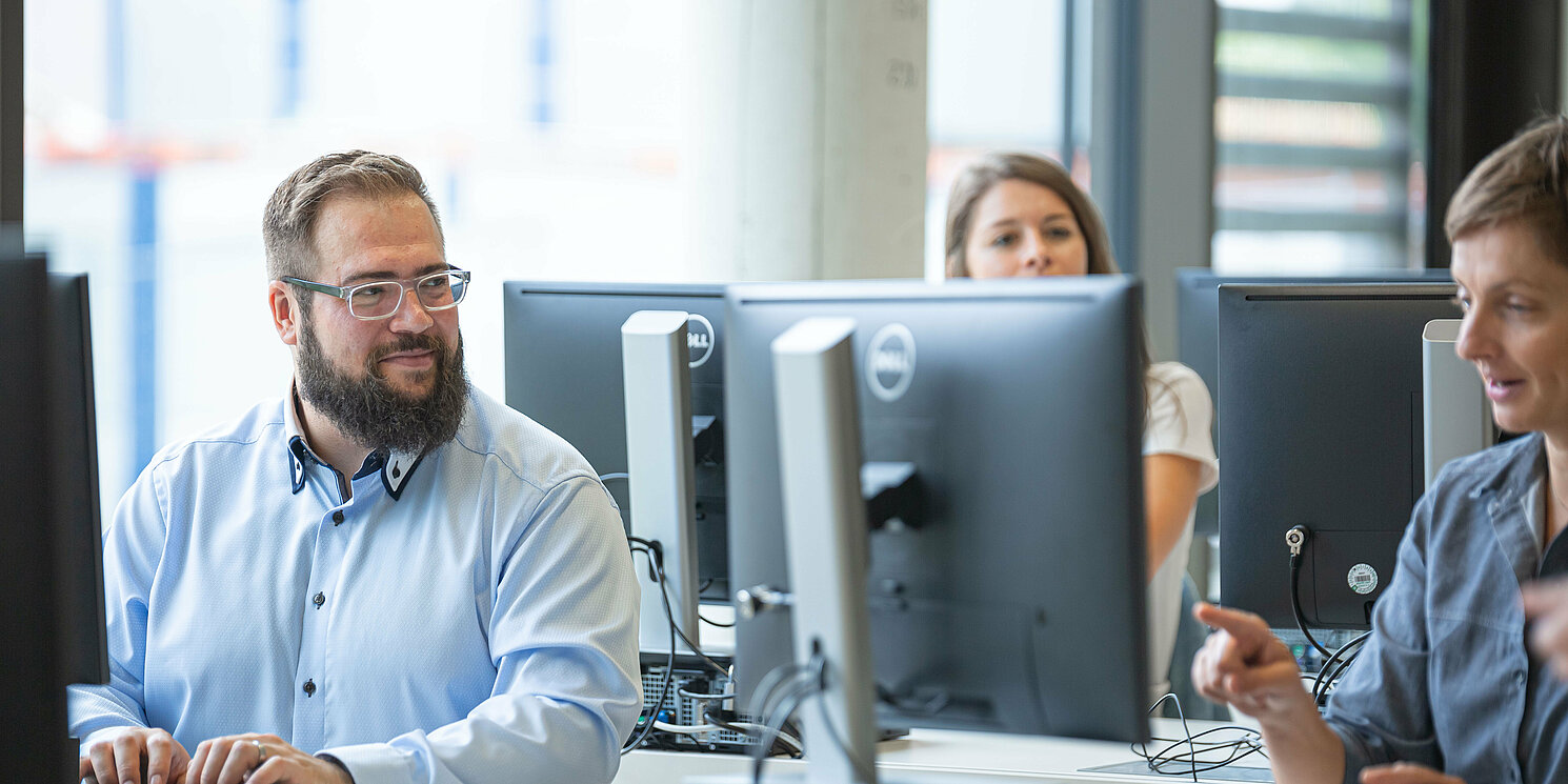 Studierende arbeiten in einem Computerraum an ihren Rechnern.