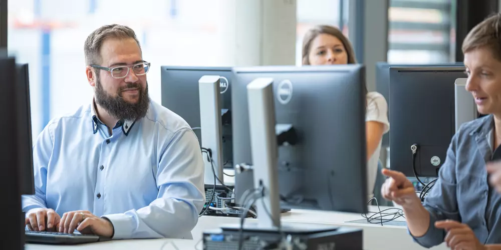 Studierende arbeiten in einem Computerraum an ihren Rechnern.