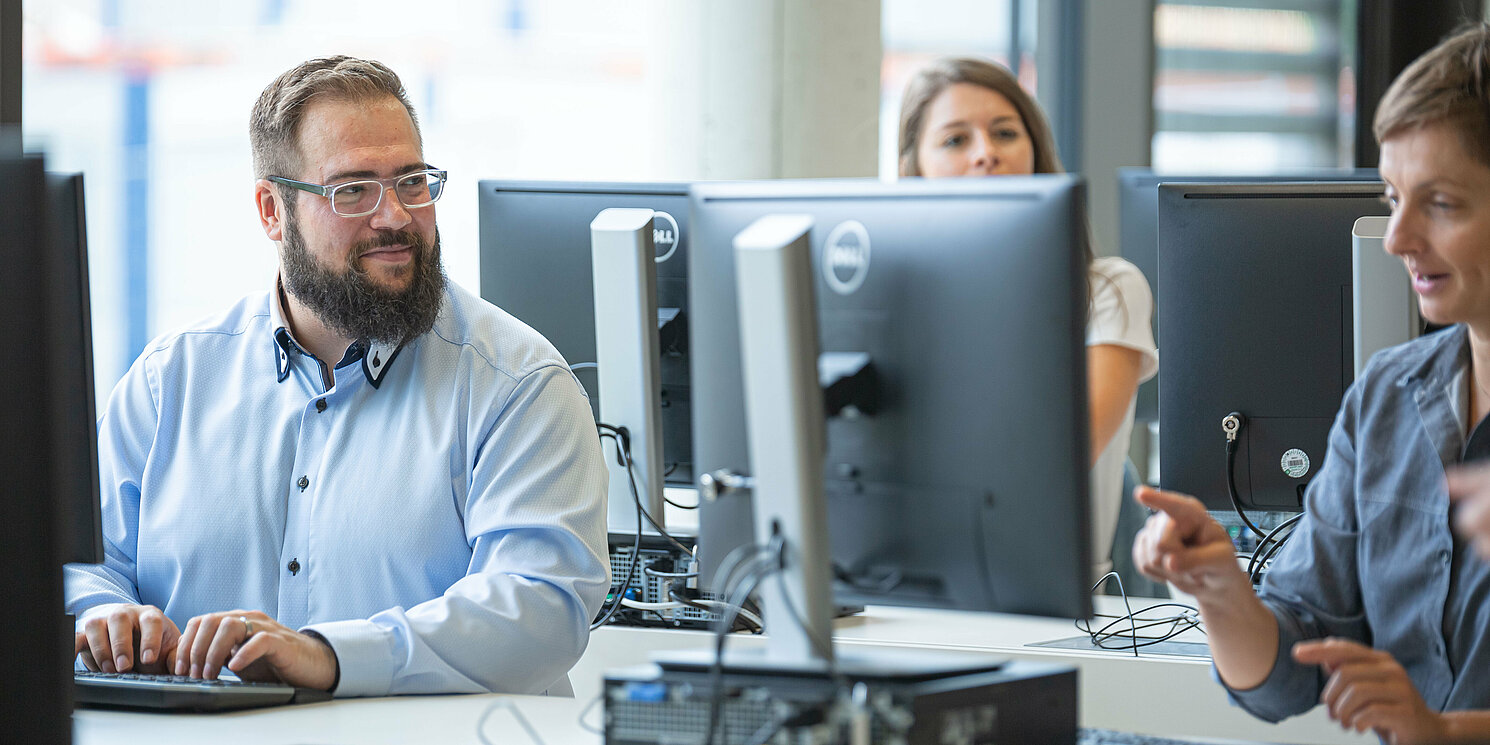 Studierende arbeiten in einem Computerraum an ihren Rechnern.