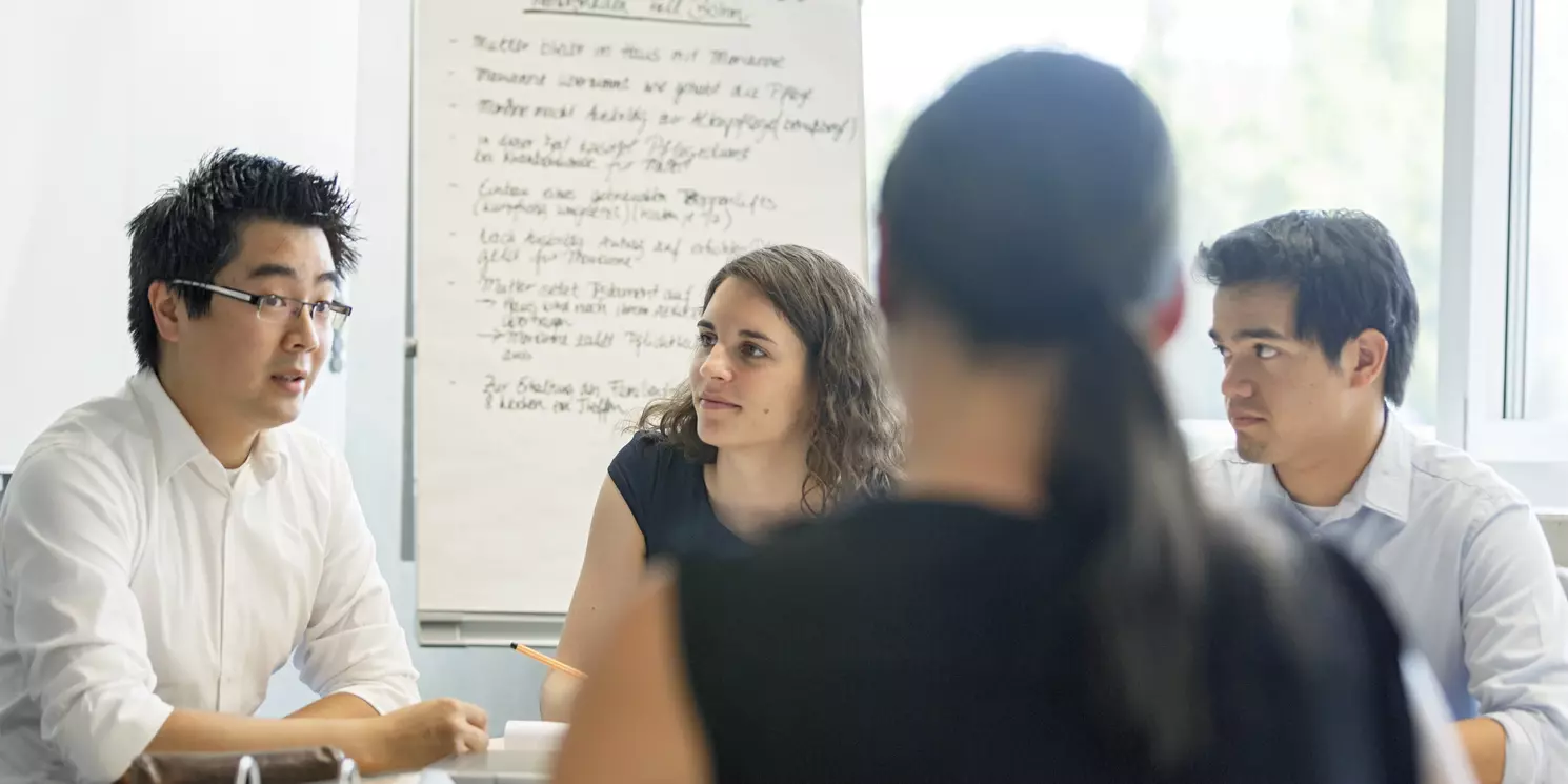 Fachseminar Online-Mediation berufsbegleitend absolvieren Vier Studiereden lernen gemeinsam in einem Seminarraum