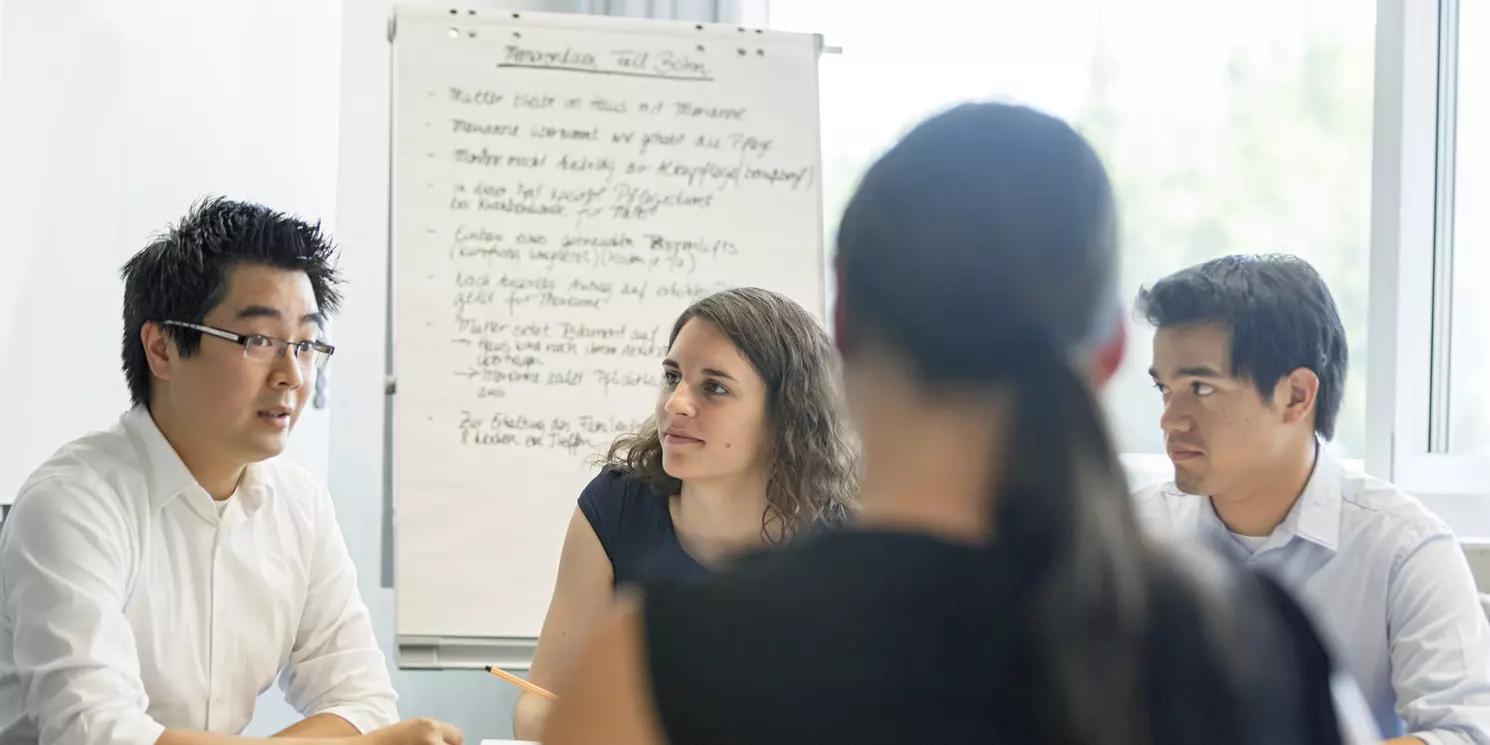 Hochschulzertifikat Mediation berufsbegleitend absolvieren Vier Studiereden lernen gemeinsam in einem Seminarraum