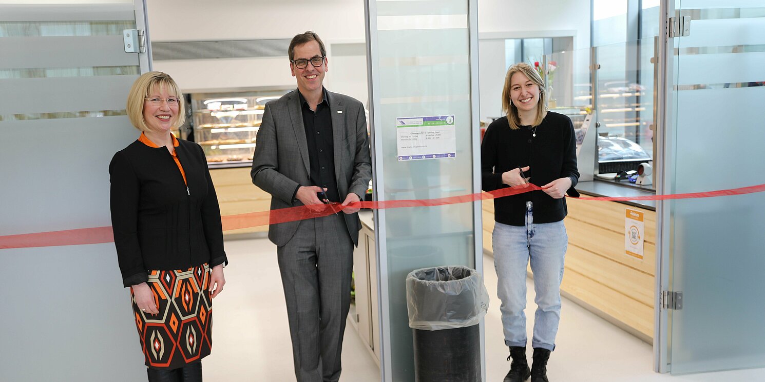Doreen Steudte (links) freut sich über die feierliche Übergabe der neuen Cafeteria an das Studentenwerk durch Prof. Dr. Ralph Schneider, Präsident der OTH Regensburg, und Studierendenvertreterin Carolina Feistl. Foto: STWNO/Nicolas Müller