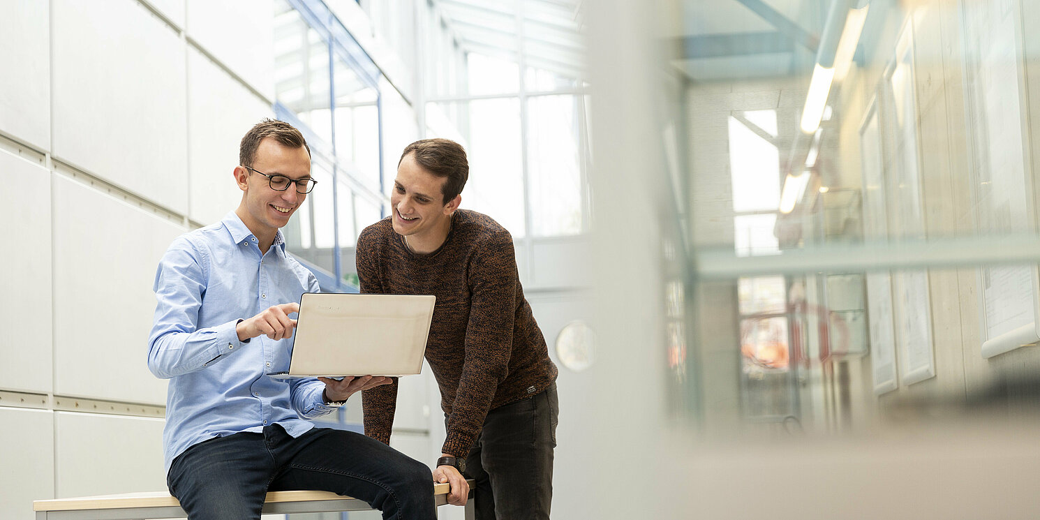 Zwei Studenten schauen in einen Laptop