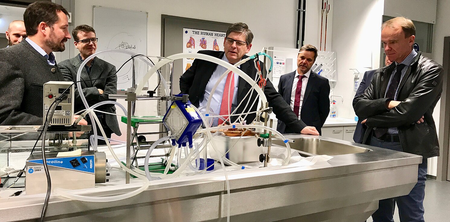 Prof. Dr. Lars Krenkel erörtert die Funktionsweise eines Versuchsstands zu einem isolierten, perfundierten Schweineherzen, mit dem Gerinnungseffekte in künstlichen Lungen untersucht werden sollen. Foto: Leis, RCBE