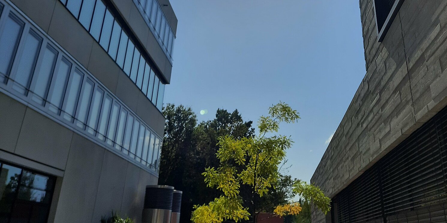 Ein blauer Himmel; Links und rechts jeweils ein Gebäude mit vielen Fenstern