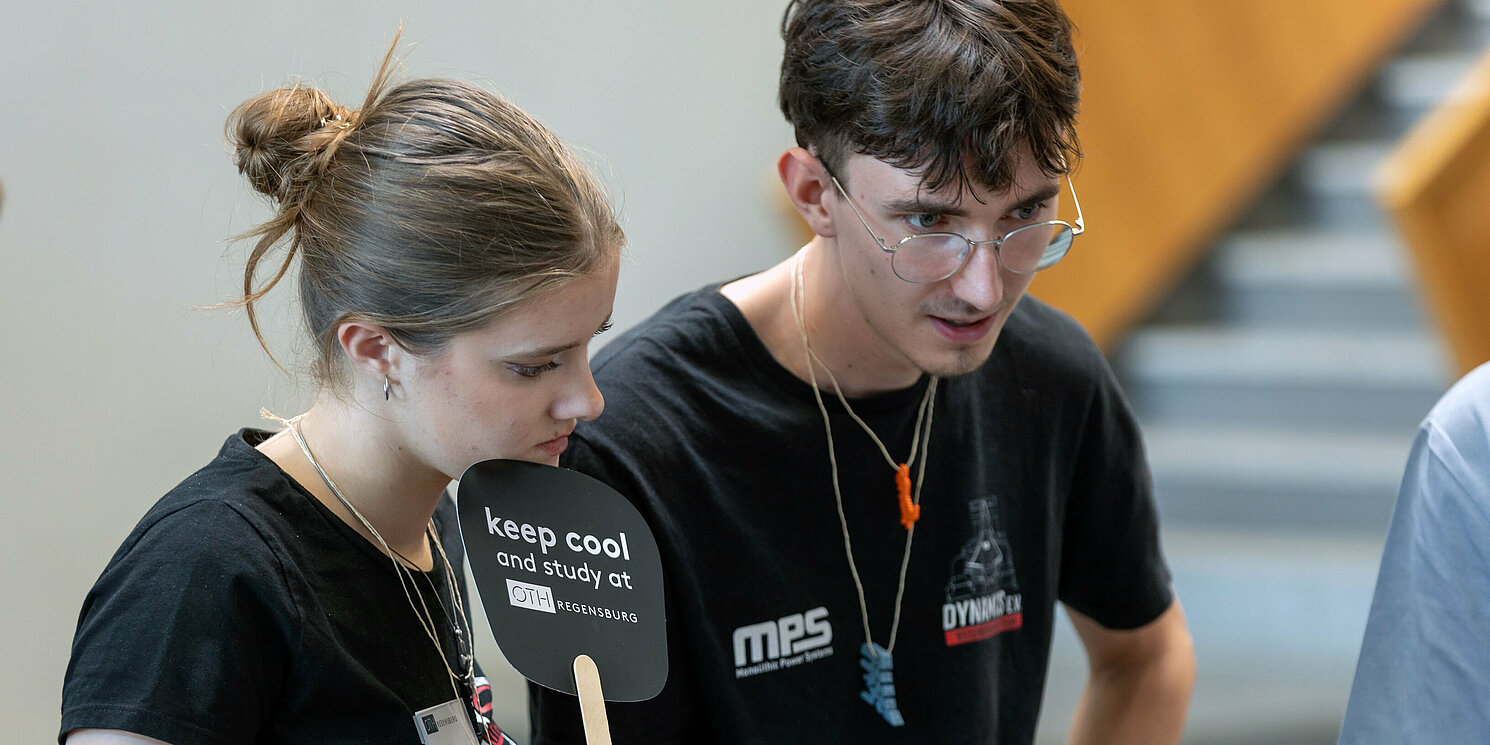Studierende mit OTH Regensburg Fächer beim Tag der offenen Hochschule der OTH Regensburg
