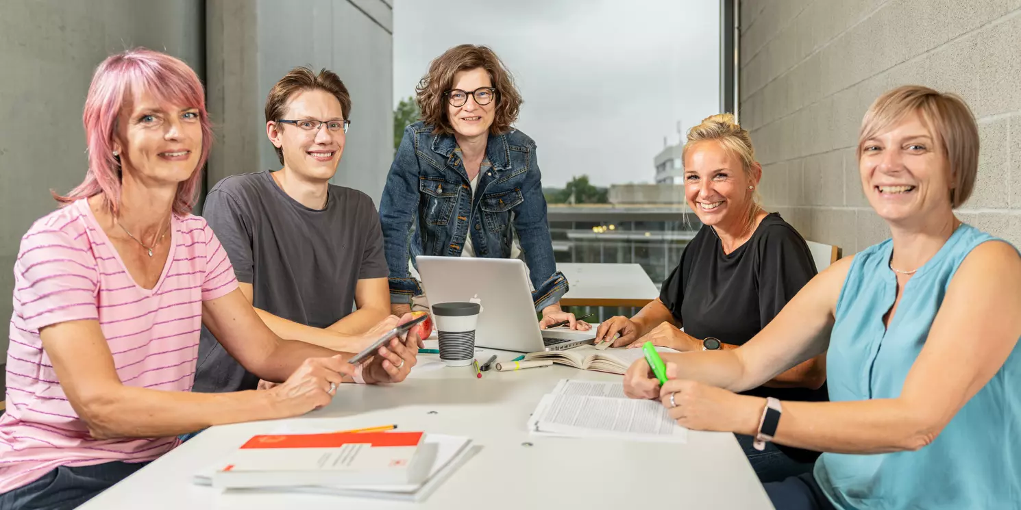 Eine Lerngruppe arbeitet gemeinsam an einem Tisch.