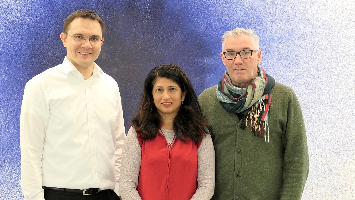 Von links: Prof. Dr. Markus Westner mit den beiden Gastdozierenden aus Neuseeland Dr. Sarita Pais und Dr. Steven McKinlay vor dem Kunstwerk „Anomalia“ im Fakultätsgebäude Informatik und Mathematik an der OTH Regensburg.
