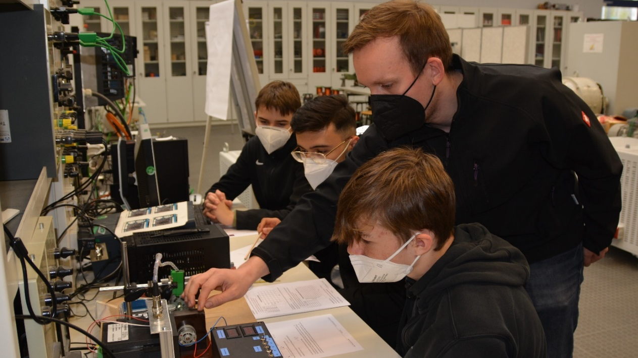 Laboringenieur Johannes Weiß und eine Schülergruppe im Labor „Elektrische Maschinen“.