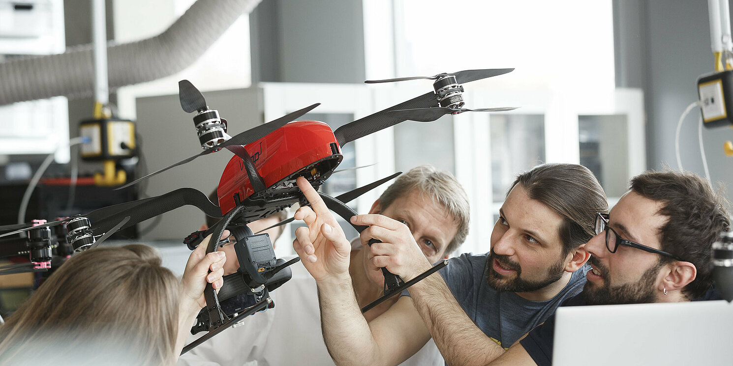 Studierende untersuchen Modell-Hubschrauber