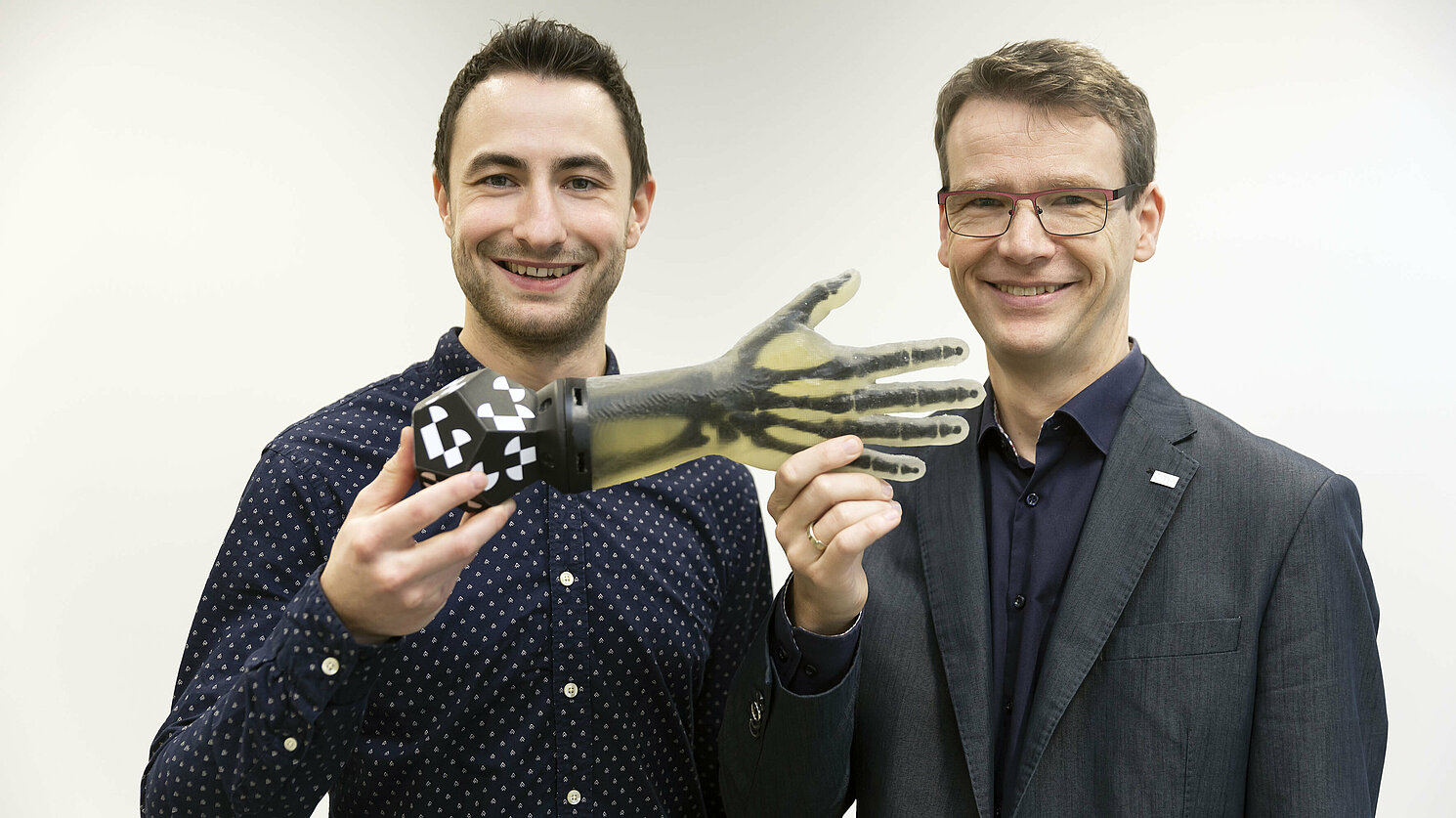 Der Preisträger des diesjährigen Biopark-Innovationspreises Johannes Maier (links) und Prof. Dr. Christoph Palm vom Regensburg Center of Biomedical Engineering von OTH Regensburg und Universität Regensburg mit dem Handphantom, welches Maier entwickelt hat. Fotos: OTH Regensburg / Florian Hammerich