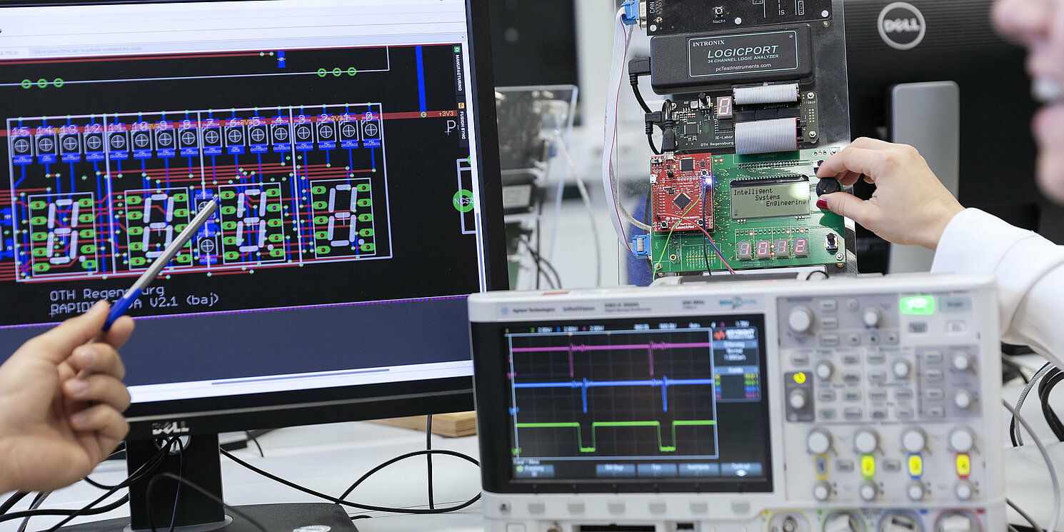 Zwei Studierende arbeiten an einem Versuchsaufbau mit einem Mikrocontroller.